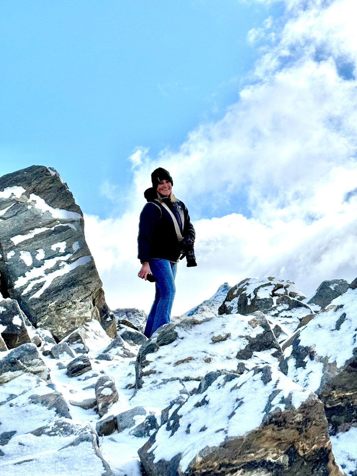 Megan standing among snowy mountain rocks in Switzerland